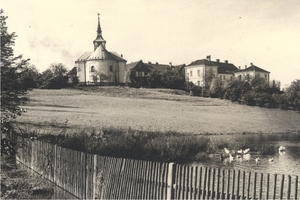 r. 1930 - zadní pohled na kostel, vpravo budovy tzv. Bílé a Červené školy.jpg